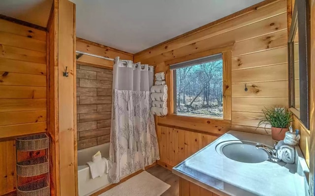 bathroom with wooden walls, vanity, wood-type flooring, and shower / tub combo