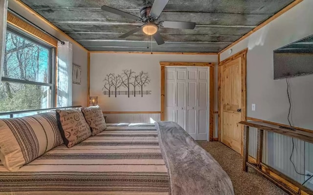 carpeted bedroom featuring ceiling fan and a closet