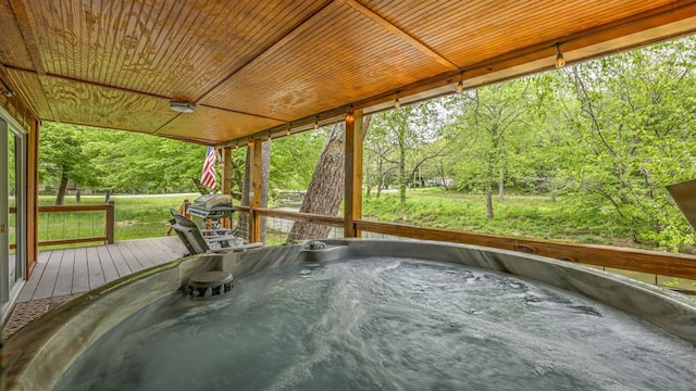 wooden terrace with a grill, a yard, and a hot tub