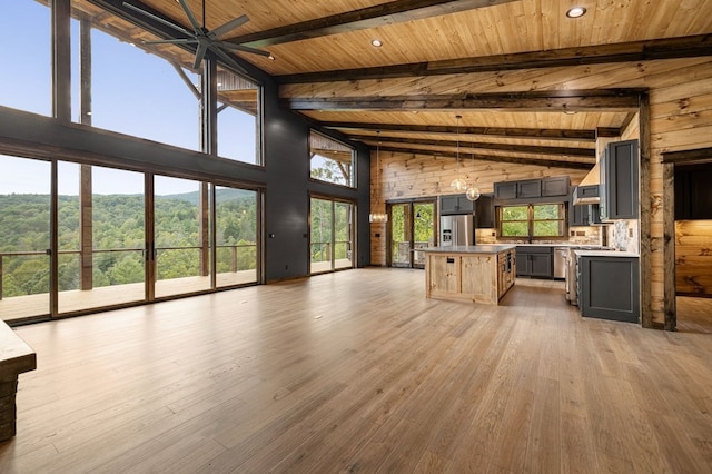 kitchen featuring high vaulted ceiling, stainless steel fridge, hardwood / wood-style flooring, wood ceiling, and beam ceiling