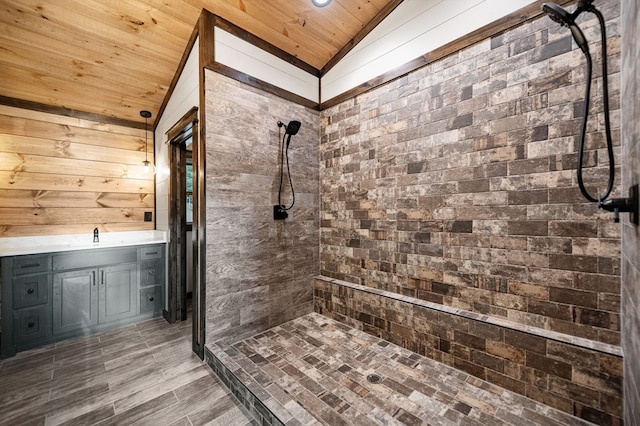 bathroom with tiled shower, lofted ceiling, wood walls, wooden ceiling, and vanity