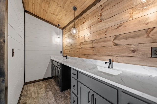 bathroom featuring vaulted ceiling, wooden walls, hardwood / wood-style flooring, vanity, and wooden ceiling