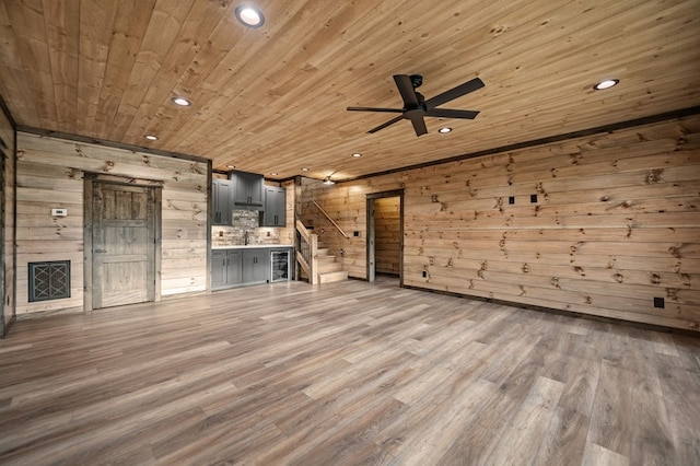 unfurnished living room with wood ceiling, hardwood / wood-style flooring, ceiling fan, wooden walls, and wine cooler