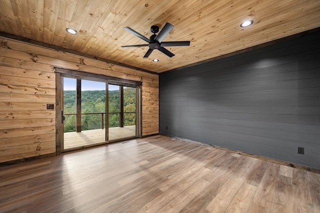 spare room featuring hardwood / wood-style flooring, ceiling fan, wooden walls, and wooden ceiling