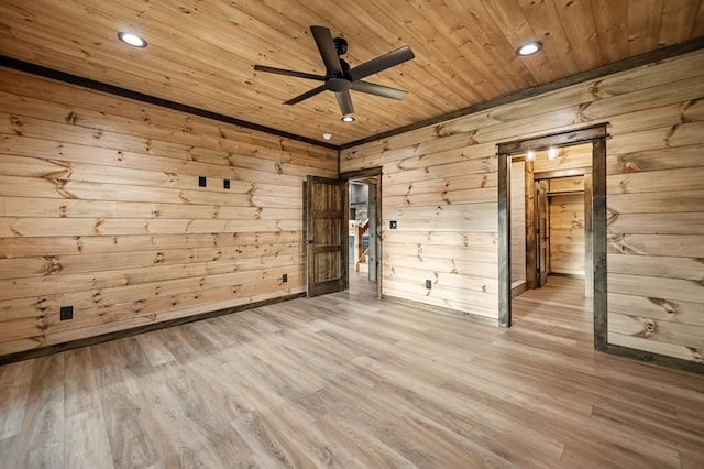 unfurnished room featuring wood ceiling, ceiling fan, wooden walls, and light hardwood / wood-style floors