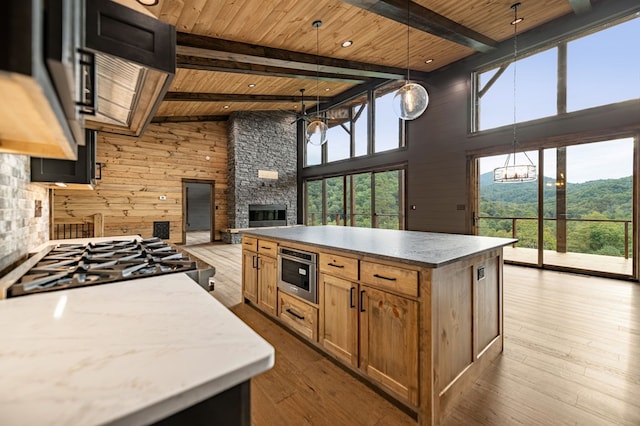 kitchen with wood ceiling, beam ceiling, decorative light fixtures, and light hardwood / wood-style floors