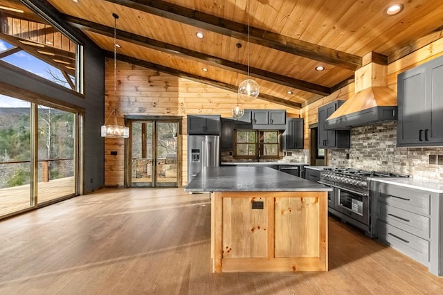 kitchen with light hardwood / wood-style flooring, gray cabinets, appliances with stainless steel finishes, high vaulted ceiling, and decorative light fixtures