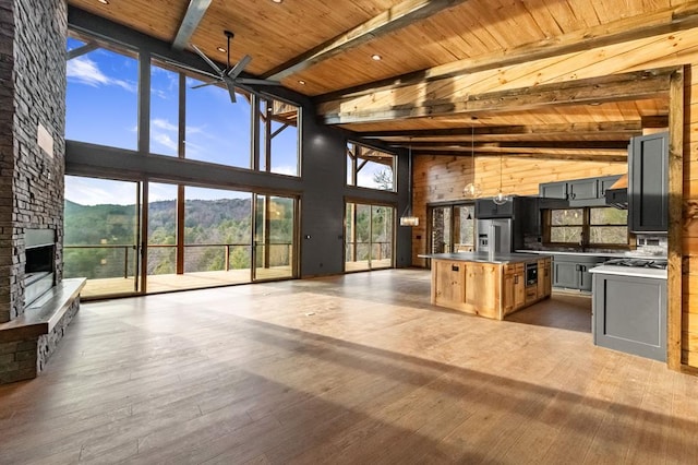 living room featuring a towering ceiling, hardwood / wood-style floors, beamed ceiling, wood ceiling, and a mountain view