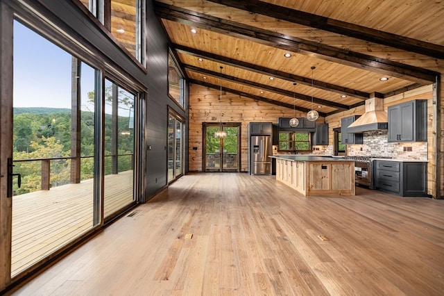 kitchen featuring wood ceiling, hardwood / wood-style flooring, premium range hood, stainless steel appliances, and decorative backsplash