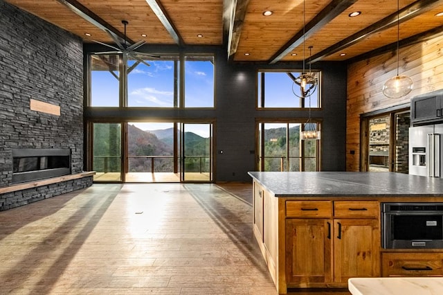 kitchen featuring a mountain view, a towering ceiling, wooden ceiling, and beamed ceiling