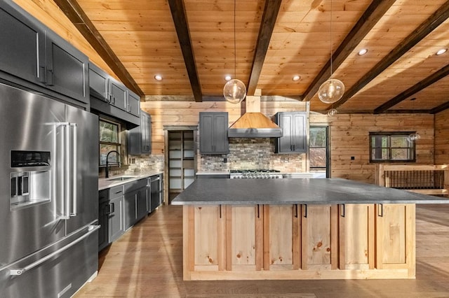 kitchen featuring high quality fridge, wooden ceiling, custom range hood, and wood walls