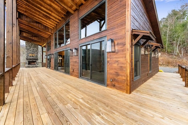 wooden deck with an outdoor stone fireplace