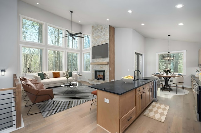 kitchen featuring a kitchen island with sink, a sink, a kitchen breakfast bar, open floor plan, and pendant lighting