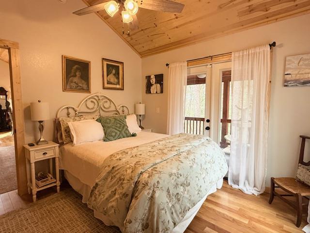 bedroom with lofted ceiling, access to exterior, light wood-type flooring, and wooden ceiling