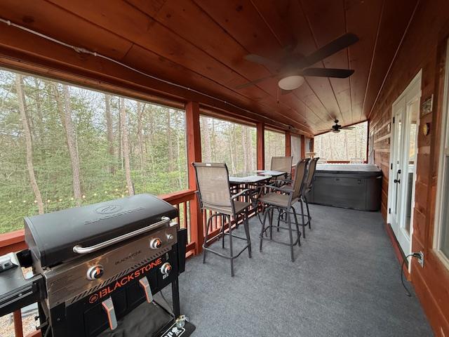 sunroom with wood ceiling, a healthy amount of sunlight, and ceiling fan