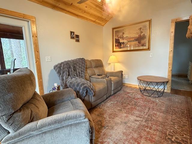 living room with vaulted ceiling, ceiling fan, wood ceiling, and baseboards