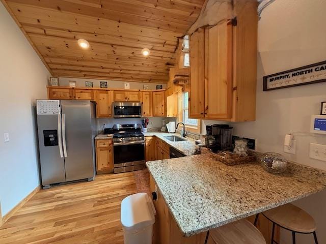 kitchen featuring appliances with stainless steel finishes, wood ceiling, a sink, light stone countertops, and a peninsula