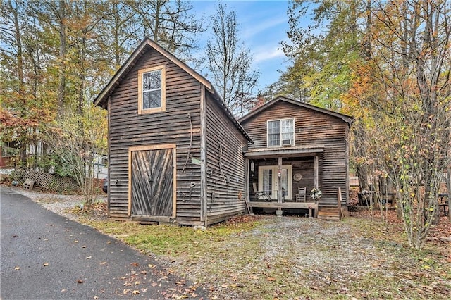 back of property featuring covered porch