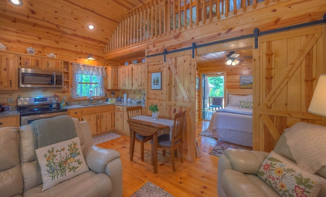 15 June Marie Ln, Murphy, NC 28906 - kitchen with stainless steel appliances, open floor plan, a barn door, wooden ceiling, and wooden walls