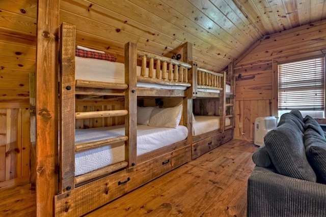 bedroom with lofted ceiling, wood ceiling, wood walls, and hardwood / wood-style floors