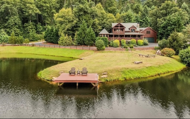 dock area with a lawn and a water view