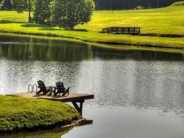 view of dock featuring a water view and a yard