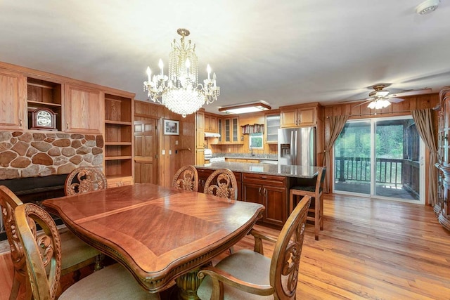 132 Silver Birch Ln, Marble, NC 28905 - dining space featuring a chandelier, light wood-style flooring, ceiling fan, wooden walls, and a stone fireplace
