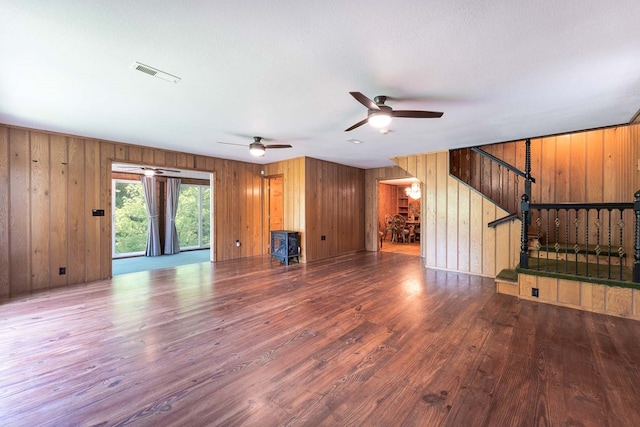 132 Silver Birch Ln, Marble, NC 28905 - unfurnished living room featuring wooden walls, wood finished floors, a ceiling fan, and stairs