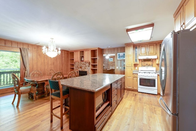 132 Silver Birch Ln, Marble, NC 28905 - kitchen featuring stainless steel appliances, under cabinet range hood, wooden walls, light wood finished floors, and a chandelier