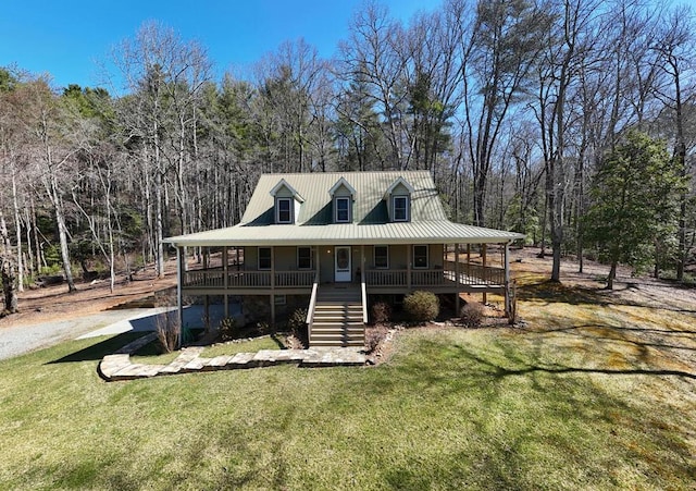 farmhouse-style home featuring stairs, a porch, a front lawn, and metal roof