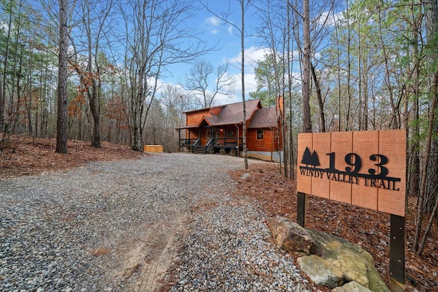 exterior space with covered porch, driveway, and a chimney