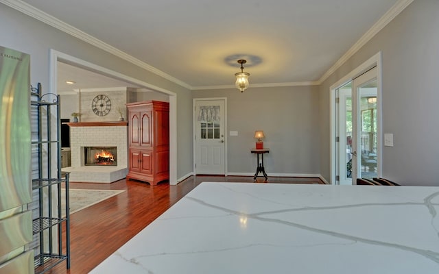 bedroom with ornamental molding, a brick fireplace, and dark hardwood / wood-style flooring