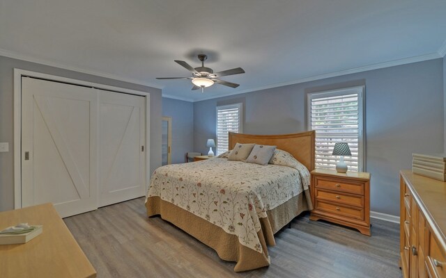 bedroom featuring ornamental molding, ceiling fan, light hardwood / wood-style floors, and a closet