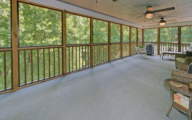 unfurnished sunroom featuring ceiling fan