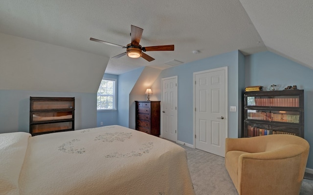 carpeted bedroom featuring ceiling fan, lofted ceiling, and a textured ceiling