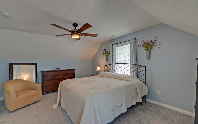 carpeted bedroom featuring ceiling fan, vaulted ceiling, and a textured ceiling