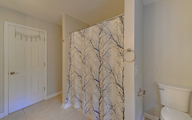 bathroom with tile patterned floors, a textured ceiling, and toilet