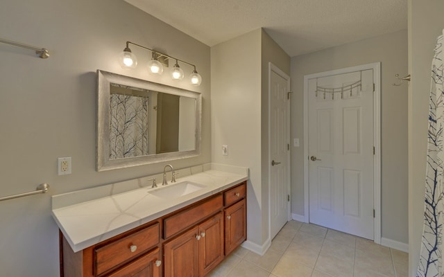 bathroom with tile patterned flooring, vanity, and a textured ceiling