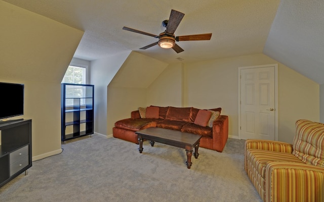 carpeted living room with ceiling fan, vaulted ceiling, and a textured ceiling