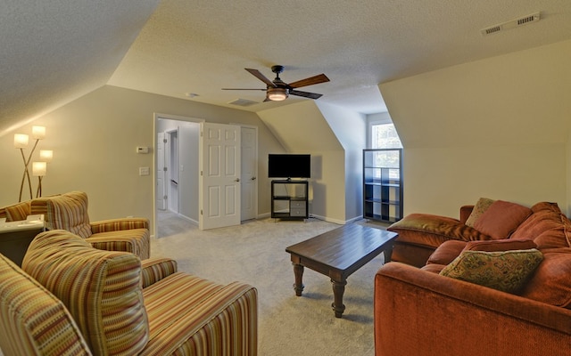 carpeted living room featuring lofted ceiling, ceiling fan, and a textured ceiling