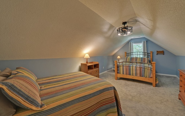 carpeted bedroom featuring vaulted ceiling and a textured ceiling