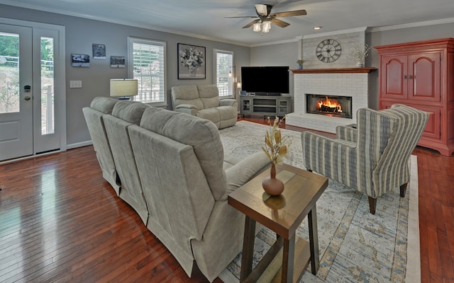 living room featuring a fireplace, dark wood-type flooring, ornamental molding, and ceiling fan