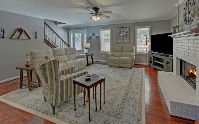 living room with crown molding, ceiling fan, a brick fireplace, and hardwood / wood-style flooring