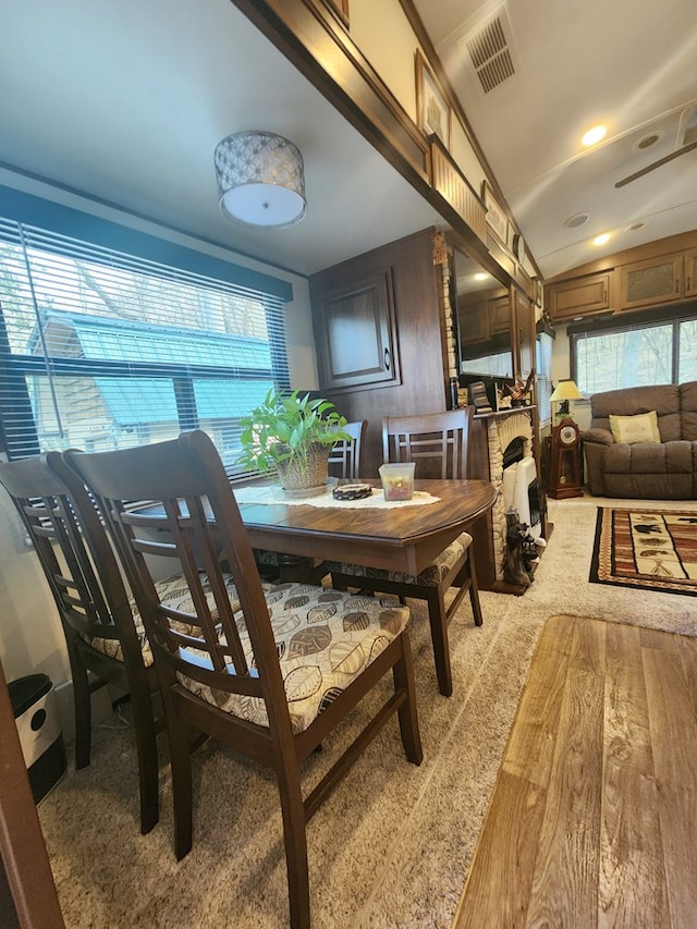 dining space with lofted ceiling, visible vents, and light wood-style flooring