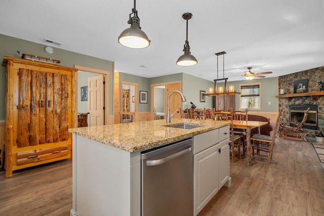 kitchen with visible vents, stainless steel dishwasher, wood finished floors, a ceiling fan, and a sink