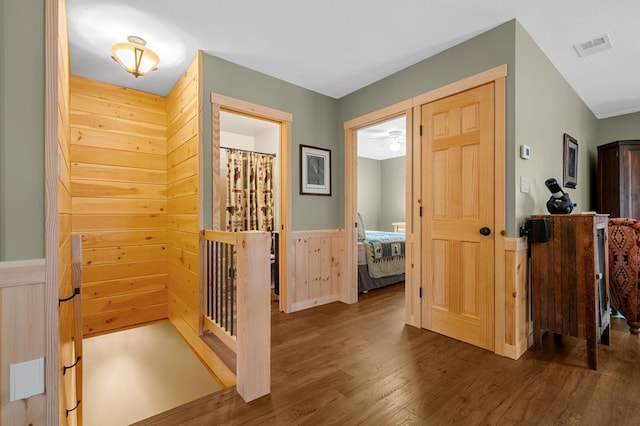 foyer entrance with visible vents, wood finished floors, and a wainscoted wall