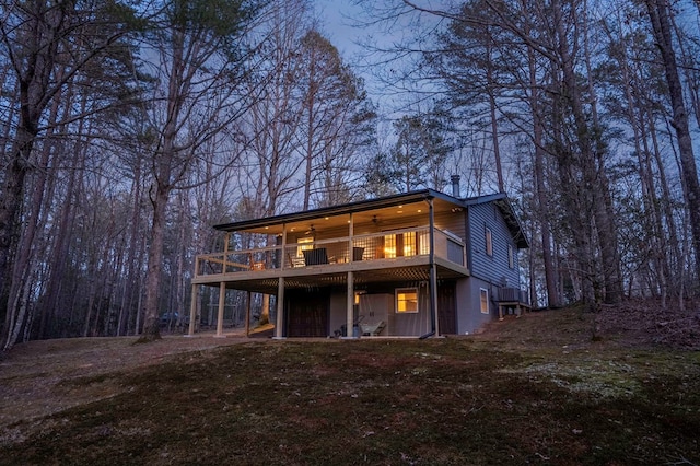 back of property featuring a deck, a chimney, and ceiling fan