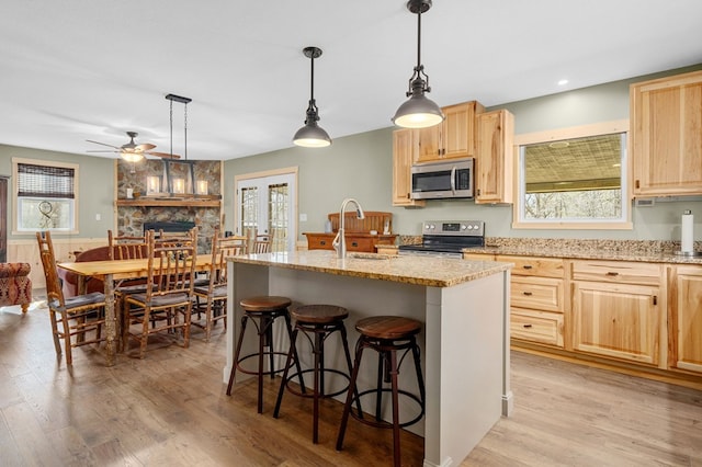 kitchen with a sink, stainless steel appliances, plenty of natural light, and light brown cabinetry