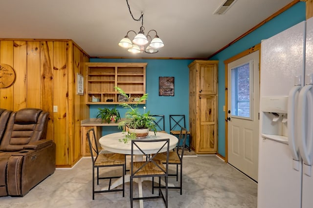 dining room with ornamental molding and an inviting chandelier