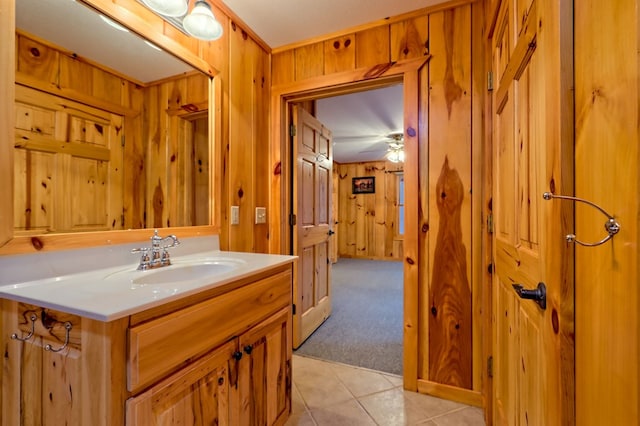 bathroom featuring tile patterned floors, vanity, and wooden walls